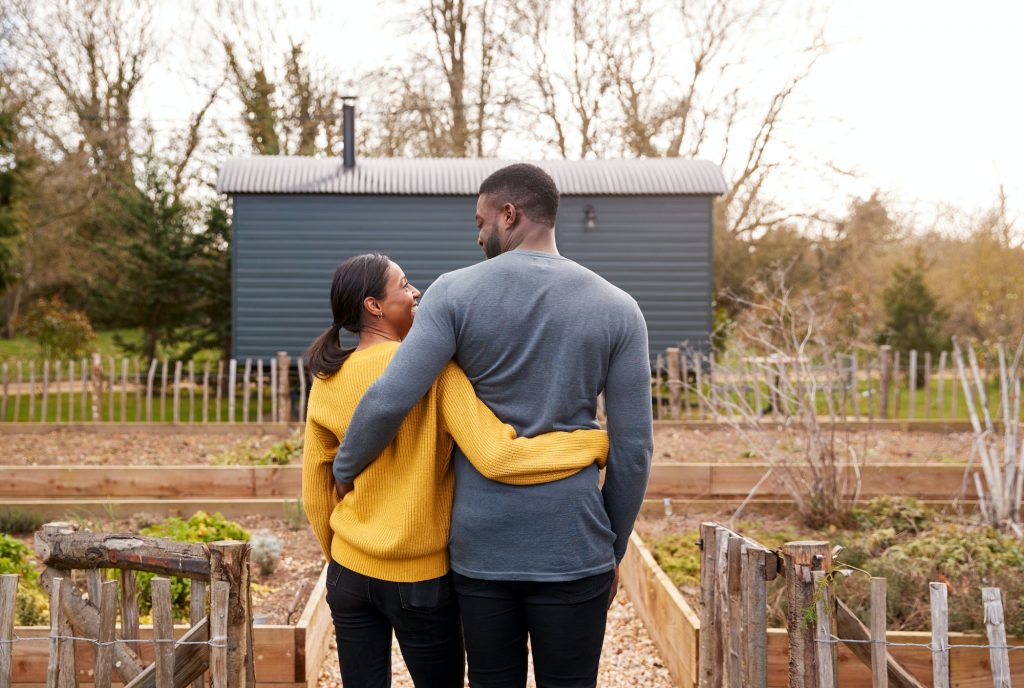 Rear View Of Couple Outdoors Spending Vacation In Eco Lodge